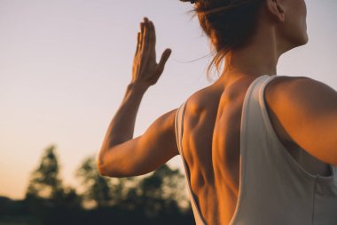 Doğada yoga yapan genç bir kadın. Kız dışarıda yoga yapıyor. İnce, güçlü ve esnek vücutlu bir kadın yoga egzersizi yapıyor. Sağlıklı yaşam tarzları. Canlılık, farkındalık, zen enerjisi kavramı.