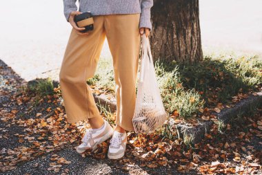 Düşük atık, plastiksiz, vejetaryen şehir yaşam tarzı kavramı. Pamukta organik yiyecekleri olan bir kadın sıfır atık dükkanından fotokopi alanı ile kullanılabilir ağ torbası. Plastik poşet olmadan sürdürülebilir alışveriş
