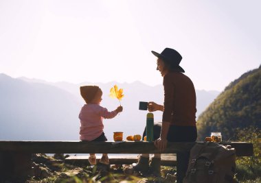 Mutlu aile sonbahar tatilinin tadını çıkarıyor. Anne ve kızı dağlarda piknik yapıyor. Anne ve küçük kız dışarıda dinleniyorlar. Çocuklarla macera yolculuğu, kamp ve doğa yürüyüşü..
