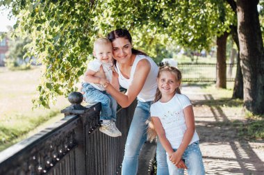 Anne ve kızları yaz parkında yürüyorlar.    