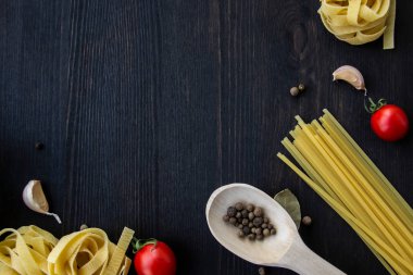 Yemek pişirme arka planında mesaj için boş yer var. Spagetti, domates, yumurta, sarımsak, ahşap arka planda defne yaprağı. Fotokopi alanı ile yemek yapmak için gerekli malzemeler. Tasarım için üst görünüm
