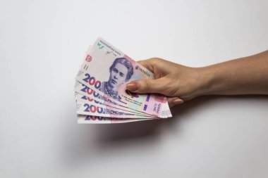 Kadın eli bin tane Hryvnia tutar. Beyaz arka planda kadın eli olan Ukrayna parası. İki yüz Hryvnia 'lı 1000 Hryvnia, beş banknot. Ukrayna parası. Ukrayna 'nın banknotları