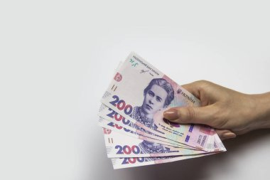 Kadın eli bin tane Hryvnia tutar. Beyaz arka planda kadın eli olan Ukrayna parası. İki yüz Hryvnia 'lı 1000 Hryvnia, beş banknot. Ukrayna parası. Ukrayna 'nın banknotları