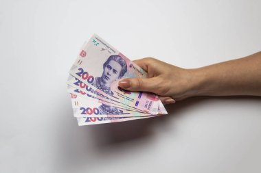 Kadın eli bin tane Hryvnia tutar. Beyaz arka planda kadın eli olan Ukrayna parası. İki yüz Hryvnia 'lı 1000 Hryvnia, beş banknot. Ukrayna parası. Ukrayna 'nın banknotları