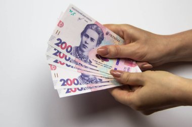 Dişi eller binlerce Hryvnia taşır. Beyaz arka planda kadın eli olan Ukrayna para birimi. İki yüz Hryvnia 'lı 1000 Hryvnia, beş banknot. Ukrayna parası. Ukrayna 'nın banknotları