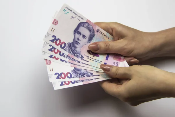 Dişi eller binlerce Hryvnia taşır. Beyaz arka planda kadın eli olan Ukrayna para birimi. İki yüz Hryvnia 'lı 1000 Hryvnia, beş banknot. Ukrayna parası. Ukrayna 'nın banknotları