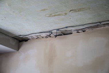 Apartmanda tamirat var. Ev tadilatı ya da yenileme kavramı. Elektrik için duvarları ve kabloları boyarken