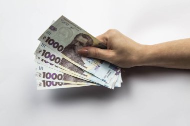 Kadın eli beş bin Hryvnia tutar. Beyaz arka planda kadın eli olan Ukrayna parası. 5000 Hryvnia ve 1000 Hryvnia 5 banknot. Ukrayna parası. Banknotlar