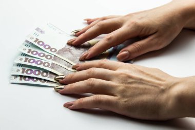 Dişi eller 5000 Hryvnia taşır. Beyaz arka planda kadın eli olan Ukrayna para birimi. 5000 Hryvnia ve 1000 Hryvnia 5 banknot. Ukrayna parası. Banknotlar