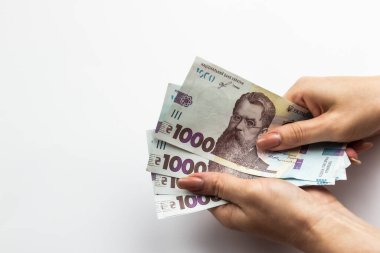 Dişi eller 5000 Hryvnia taşır. Beyaz arka planda kadın eli olan Ukrayna para birimi. 5000 Hryvnia ve 1000 Hryvnia 5 banknot. Ukrayna parası. Banknotlar