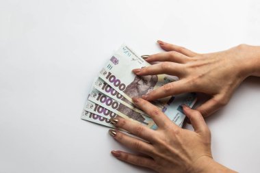 Dişi eller 5000 Hryvnia taşır. Beyaz arka planda kadın eli olan Ukrayna para birimi. 5000 Hryvnia ve 1000 Hryvnia 5 banknot. Ukrayna parası. Banknotlar