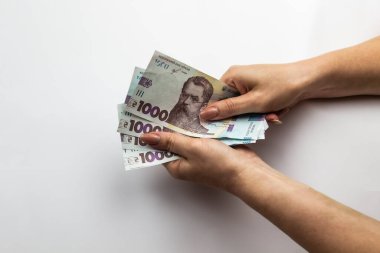 Dişi eller 5000 Hryvnia taşır. Beyaz arka planda kadın eli olan Ukrayna para birimi. 5000 Hryvnia ve 1000 Hryvnia 5 banknot. Ukrayna parası. Banknotlar