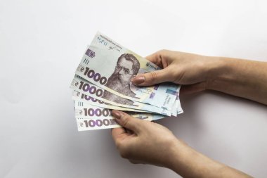 Dişi eller 5000 Hryvnia taşır. Beyaz arka planda kadın eli olan Ukrayna para birimi. 5000 Hryvnia ve 1000 Hryvnia 5 banknot. Ukrayna parası. Banknotlar