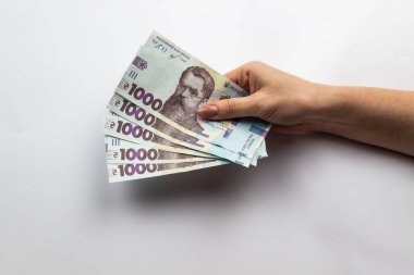 Dişi eller 5000 Hryvnia taşır. Beyaz arka planda kadın eli olan Ukrayna para birimi. 5000 Hryvnia ve 1000 Hryvnia 5 banknot. Ukrayna parası. Banknotlar