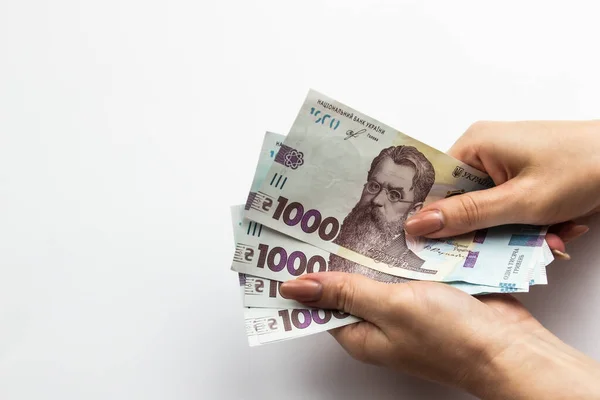 Dişi eller 5000 Hryvnia taşır. Beyaz arka planda kadın eli olan Ukrayna para birimi. 5000 Hryvnia ve 1000 Hryvnia 5 banknot. Ukrayna parası. Banknotlar