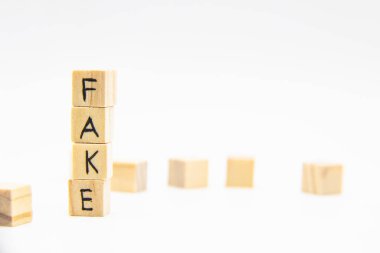 Tahta küplere yazılmış sahte bir kelime. Beyaz üzerine izole edilmiş tahta küplerden yapılmış sahte harfler.