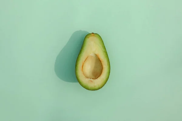 Avocado op een gekleurde achtergrond voedsel patroon — Stockfoto