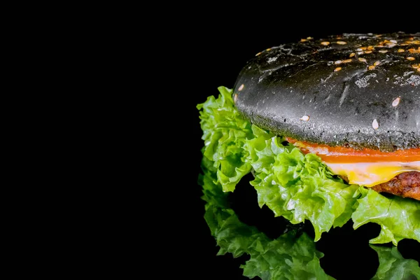 Schwarzer Hamburger in Großaufnahme auf schwarzem Hintergrund — Stockfoto