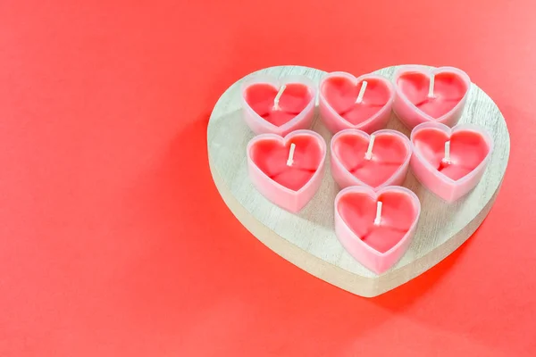 Pink candles in the form of a heart on a red background for Valentines day — Stock Photo, Image