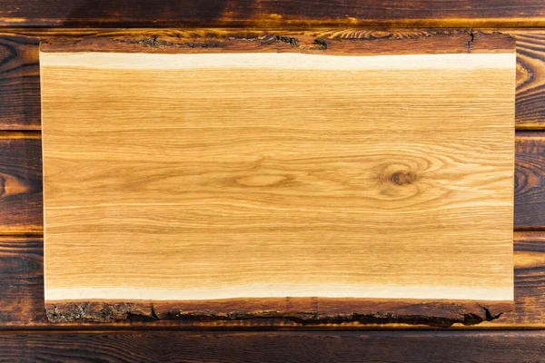 Snijplank op een houten achtergrond bovenaanzicht — Stockfoto