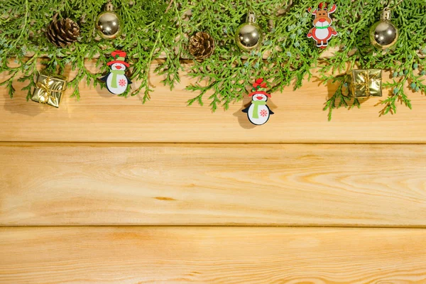 Naaldbomen takken met kerstspeelgoed op een houten achtergrond bovenaanzicht — Stockfoto