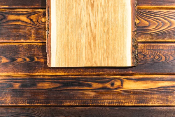 Řezací deska na dřevěném pozadí horní pohled — Stock fotografie