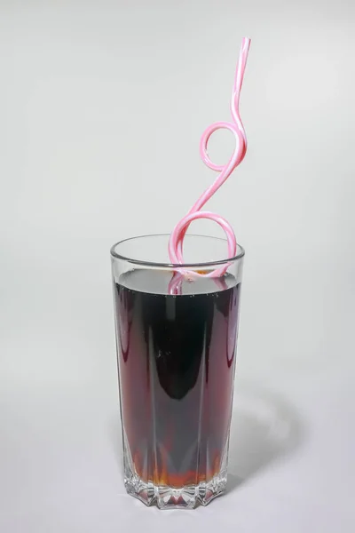 Um copo de refrigerante com um tubo em um fundo leve — Fotografia de Stock