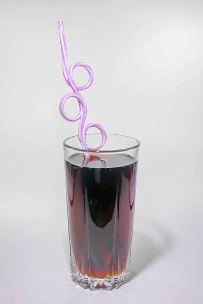 Un vaso de refresco con un tubo sobre un fondo claro —  Fotos de Stock