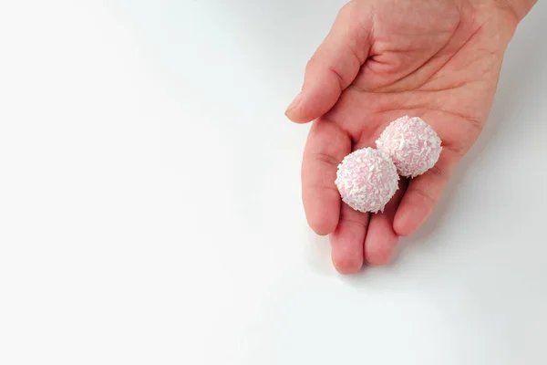 Doces de chocolate rosa na mão em um fundo branco. macro bola de doces. isolar — Fotografia de Stock