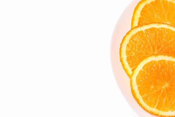 Rodajas de naranja en un plato blanco sobre un fondo blanco — Foto de Stock