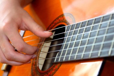 akustik gitarla melodiyi çalıyordu.