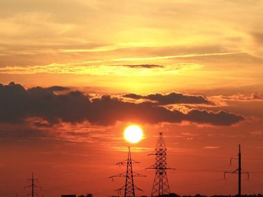 Güç hatları arka planda Kanlı günbatımı