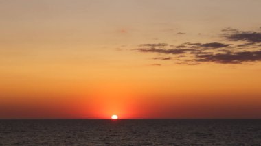 Ufukta turuncu-kırmızı gün batımı görünüyor.