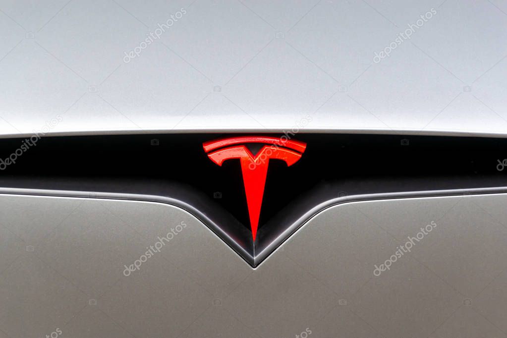 London, UK - June 2019: Red Tesla Motors logo on a car. Tesla is an American company that designs, manufactures, and sells electric cars