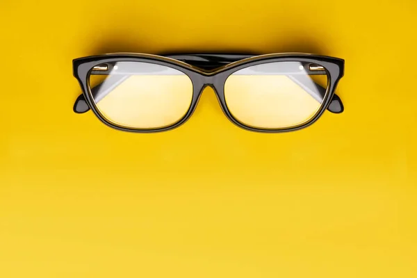 Glazen met transparante lenzen geïsoleerd op gele achtergrond. Vooraanzicht met Kopieer ruimte. — Stockfoto