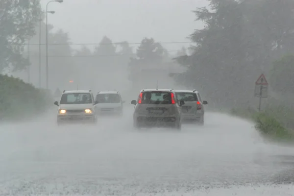 La fuerte tormenta con fuertes lluvias en la carretera con poca visibilidad de los coches. Concepto del peligro de conducir con mal tiempo Imagen De Stock