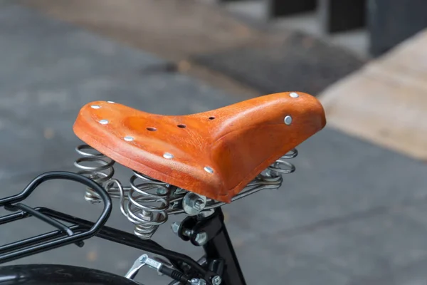 Classic leather bike saddle with metal spring. Brown bicycle seat