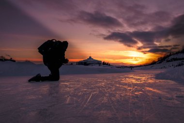 Donmuş gölde fotoğrafçılık üzerinde çalışan bir akşam. 