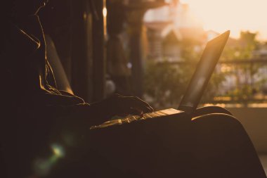 Bilgisayar ve gündoğumu arka plan üzerinde çalışan Erkekler