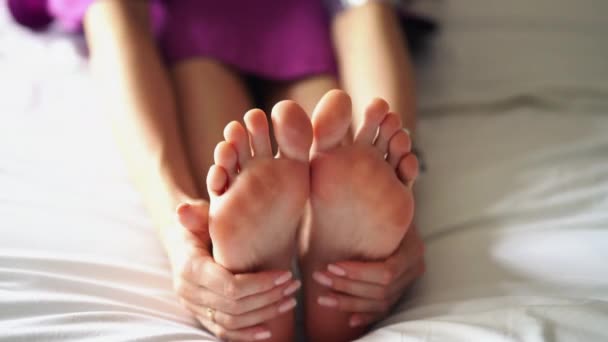 Uma mulher massaga o fundo do seu pé cansado e dolorido . — Vídeo de Stock
