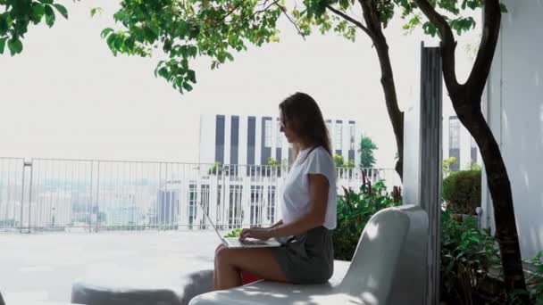 Attraktives Mädchen, das draußen am Laptop arbeitet — Stockvideo