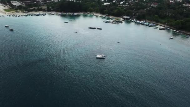 Letecký pohled na ukotvenou katamaran na jachtě stojící a lidé mohou na palubě sluneční koupel. — Stock video
