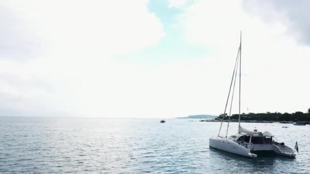 Luchtfoto van een verankerd catamaran jacht staande en mensen kunnen zonnebaden op het dek. — Stockvideo