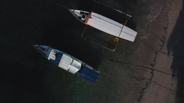 明確でターコイズブルーの水で湾に停泊するボートの空中ドローンビュー. — ストック動画