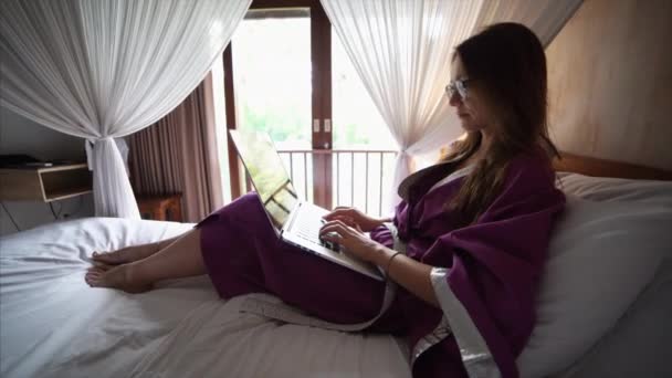 Ελκυστική νεαρή γυναίκα με μπουρνούζι είναι συνομιλία στο διαδίκτυο — Αρχείο Βίντεο