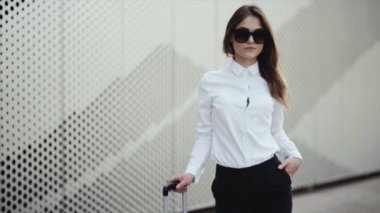 Plajda gülümseyen çekici genç kadının portresi güneş gözlüğü serin kaldırır.