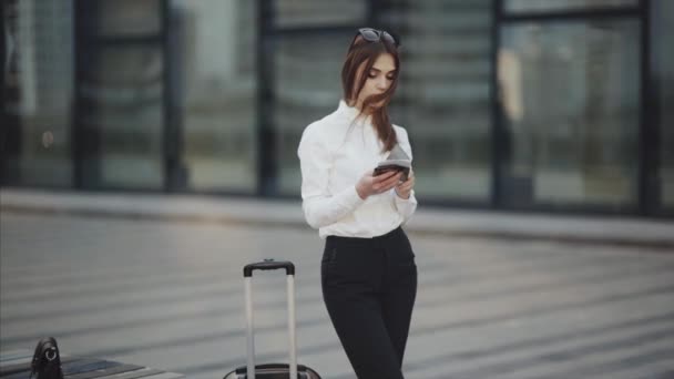 Mulher com o filho check-in online no telemóvel no hall do aeroporto . — Vídeo de Stock