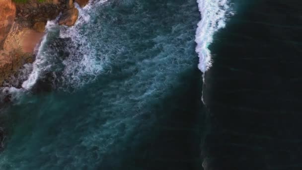 Abstracte luchtfoto van de oceaan golven crashen op rotsachtige kustlijn — Stockvideo