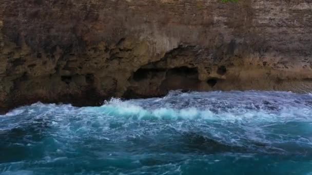 Abstracte luchtfoto van de oceaan golven crashen op rotsachtige kustlijn — Stockvideo