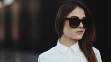 Plajda gülümseyen çekici genç kadının portresi güneş gözlüğü serin kaldırır.